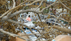 Alexa Alvarez talks to her fiancé while standing amid the rubble of Fort Myers Beach, Fla., on Sunday, Oct. 9, 2022. Hurricane Ian pummeled the coastal barrier island, and residents spent the weekend assessing damage and beginning to clean up. Alvarez's parents lost their home to the storm. (AP Photo/Jay Reeves)