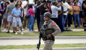 A law enforcement officer walks as people are evacuated from a shopping center where a shooting occurred on Saturday in Allen, Texas. (AP Photo/LM Otero)