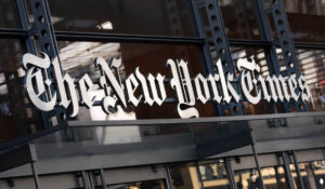 A sign for The New York Times hangs above the entrance to its building, May 6, 2021, in New York. The Athletic, a subscription sports outlet owned by The New York Times, is laying off about 4% of its newsroom staff as part of reorganization efforts, the company confirmed on Monday, June 12, 2023. (AP Photo/Mark Lennihan, File)