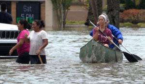 Residents paddle and walk along a flooded road in Fort Lauderdale, Fla. in April after two feet of rain caused widespread flooding. (AP Photo/Marta Lavandier)