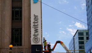 A workman removes a character from a sign on the Twitter headquarters building in San Francisco on Monday. (AP Photo/Godofredo A. Vásquez)