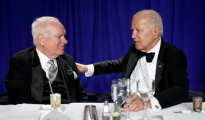 NPR president and CEO John Lansing, left, sitting with President Joe Biden at the White House Correspondents' Association dinner last April. (AP Photo/Carolyn Kaster)