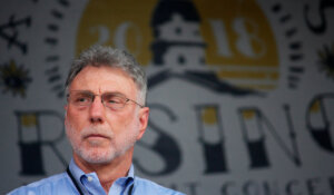 Martin Baron, then-executive editor of The Washington Post, stands on stage on Saturday, July 28, 2018 in Annapolis, Md., during a benefit concert for the five Capital Gazette employees who were killed by a gunman a month ago in their newsroom. (AP Photo/Brian Witte)