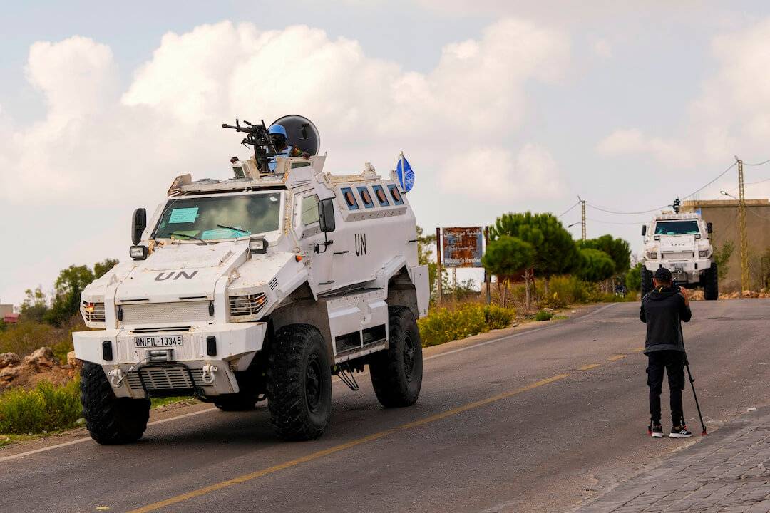 A journalist films U.N. peacekeepers patrol on the Lebanese side of the Lebanese-Israeli border in the southern village of Marwahin, Lebanon, Thursday, Oct. 12, 2023.