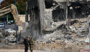 A digger removes the rubble from the police station that was overrun by Hamas militants on Saturday in Sderot, Israel. (AP Photo/Ohad Zwigenberg)