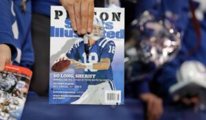 A fan holds up a copy of Sports Illustrated in 2016. (AP Photo/Darron Cummings, File)
