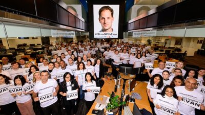 Staff at the Wall Street Journal's New York office hold signs in support of their colleague Evan Gershkovich, who was detained by Russia a year ago while on a reporting assignment. (Courtesy: Wall Street Journal)  Credit: Cam Pollack/The Wall Street Journal