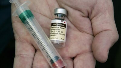 In this Aug. 28, 2006 file photo, a doctor holds the human papillomavirus vaccine Gardiasil in his hand at his Chicago office. (AP Photo/Charles Rex Arbogast, File)