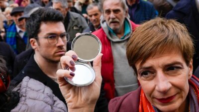 Media rights groups and opposition campaigners hold mirrors during a protest in front of Serbian appeals court, in Belgrade, Serbia, Monday, Feb. 5, 2024. Media rights groups and opposition campaigners have condemned a Serbian appeals court ruling that acquitted four former intelligence officers who were jailed for the killing of a prominent editor and newspaper publisher. (AP Photo/Darko Vojinovic)