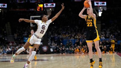 Iowa guard Caitlin Clark (22) shoots over South Carolina guard Bree Hall (23) during the first half of Sunday's Division I national championship game in Cleveland. (AP Photo/Carolyn Kaster)