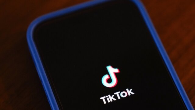 Image the Tik Tok logo on a dark screen on a phone