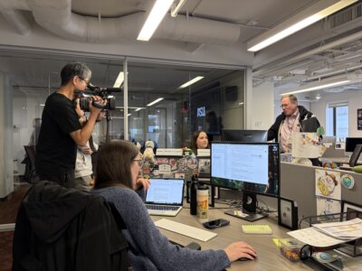 A crew from Japanese broadcaster NHK films PolitiFact staff members at work in their Washington, D.C. office for their documentary. (Sara Swann/Poynter)