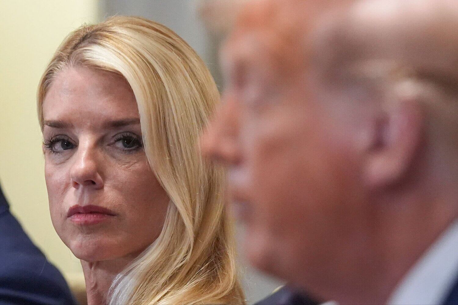 A blonde woman looks at a man to her right